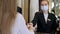 Hotel receptionists wearing medical masks, checking in young woman at the hotel room