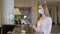 Hotel receptionists wearing medical masks, checking in young woman at the hotel room