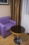 Hotel room interior with violet sofa.