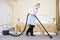 Hotel service. female housekeeping worker with vacuum cleaner