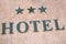 Hotel signage with three stars on stoned wall