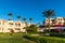 Hotel suites exterior with palms, garden and blue sky