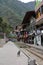 Hotels and restaurants lined along the train tracks with tourists and locals going about their day in Aguas Calientes, Peru