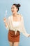 Hoto of pretty funny lady hold lollipop candy hands good mood sweets addicted person wear cropped pullover orange short skirt