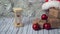 Hourglass and cardboard box on a wooden table decorated with a garland and red Christmas balls for the New Year or XMAS