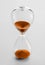 Hourglass containing orange sand isolated on white background