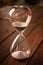 Hourglass containing white sand on a rustic wooden board