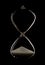 Hourglass in a dark studio with rim lighting and all the sand at