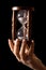 Hourglass in hands on a black