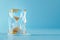 Hourglass in ice cube, frozen time. Stopping the time concept, freeze time, sand clock in ice, copy space. Climate change.