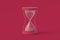 Hourglass of magenta on red background. Color of the year 2023