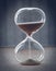 Hourglass measuring the passing time in a countdown to a deadline, on a blur background with copy space