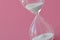 Hourglass on pink background - Concept of health, fertility and biological clock in women