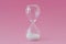 Hourglass on pink background - Concept of infertility and biological clock in women