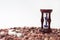 Hourglass and sea shells on the beach with red stones