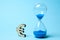 Hourglass and symbol of money euro on blue background