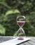 Hourglass on top of computer laptop. Close up