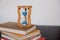 Hourglasses and book on a wooden table