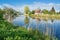 House above the river, trees and blue sky. Beautiful spring landscape in Poland