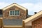 House adorned with a dormer on its roof, against the backdrop of a picturesque cloudy sky