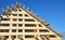 House attic wooden roofing construction. Installing wooden rafters, logs, eaves