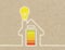 House with battery icon and light bulb metaphor for green house on brown recycled paper
