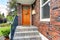 House with brick trim. Entrance porch with orange door