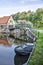 House, bridge and sloop reflecting in canal