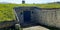 House or bunker built of stone underground with solid wood door and natural grass roof