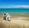 House carved out of dollar bills on the sea sand