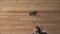 House cleaning. woman vacuuming a wooden floor in an apartment, top view