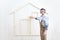 House construction renovation concept handyman carpenter worker man with meter  measure and show the model of a wooden house,