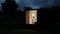 House from a construction transport container sheathed by boards against the background of nature.