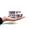 house delicately placed on a hand, symbolizing the real-estate concept of property ownership, investment, and finance.