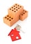 House door key with red house key chain pendant and bricks