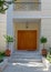 A house entrance portico with natural brown wooden doors. Visit Athens, Greece.