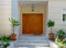 A house entrance portico with natural brown wooden doors. Visit Athens, Greece.