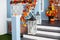 House entrance staircase decorated for autumn holidays, fall flowers and pumpkins. Cozy porch of the house with wooden lanterns in