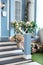 House entrance staircase at home decorated for holiday. Wooden porch of house with different flowers. Terrace of summer house