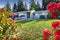 House exterior with blooming rhododendrons on front yard