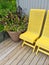 House exterior decorated with yellow chairs and flowers