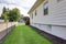 House exterior. View of side wall and green grass.