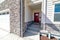 House facade with vibrant red front door attached garage and stone brick wall