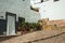 House facade with white walls, door, flower pots and plants at Caceres