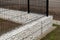 House fence. Corner made of gabions filled with white pebbles.
