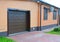 House garage door with ventilation, air conditioner, rain gutter pipeline system, security window shutters and pavement outdoor.