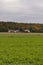 A house and habitat on the edge of a farmland and a forest on a clear autumn day. Autumn