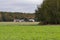 A house and habitat on the edge of a farmland and a forest on a clear autumn day. Autumn