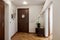 House hallway entrance interior with stairs and furniture. Apartment background with door, mirror, bag on hanger, flower in vase,