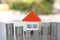 The house has an orange roof and coins that are stacked from low to high. Financial and banking concepts prepare for home buying